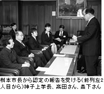桝本市長から認定の報告を受ける（前列2人目から）神子上学長、高田さん、森下さん