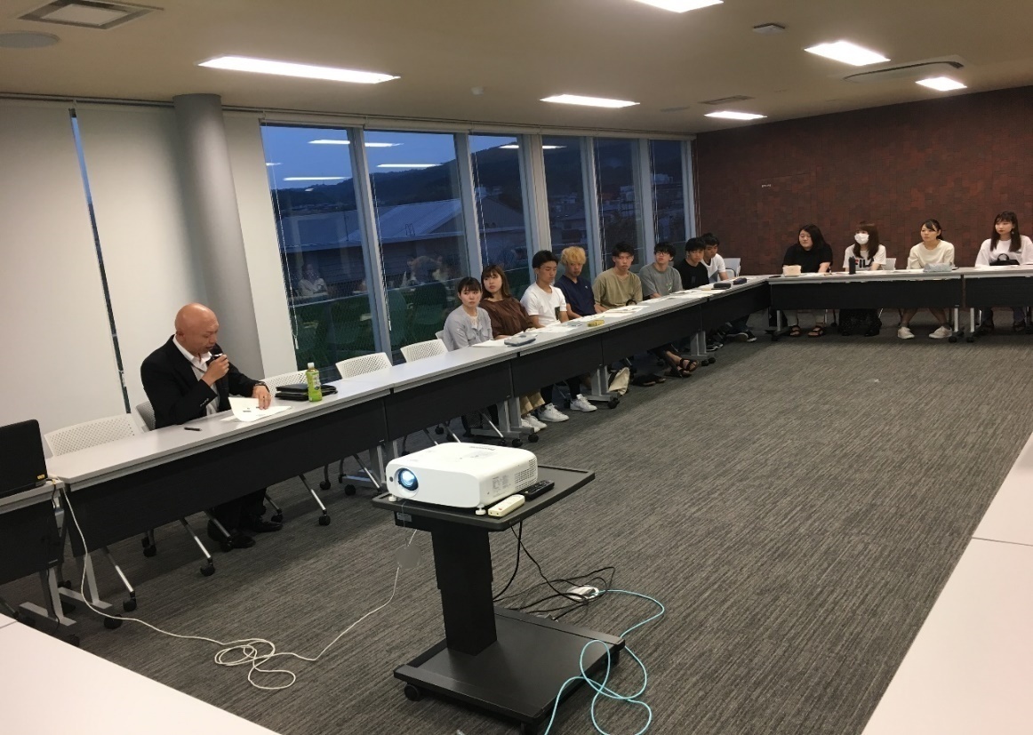 学生の報告に対してコメントされる岩崎部長と、それを聞くゼミ生(7月23日)